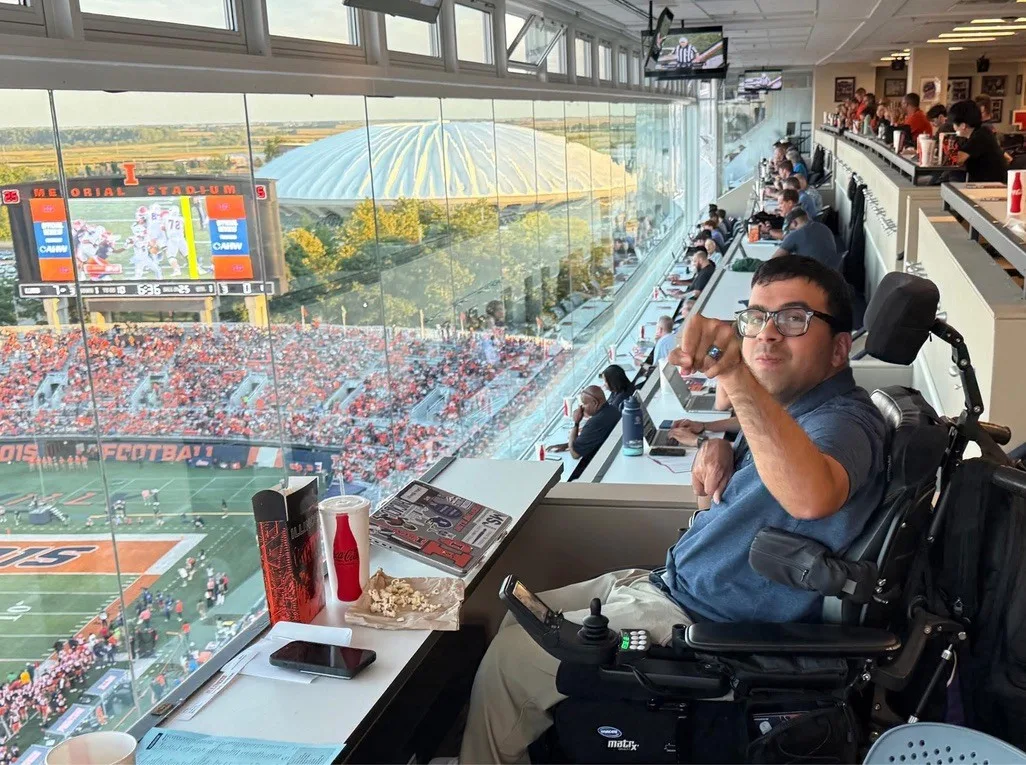 Zain Bando at his press-box seat at Memorial Stadium, Illinois football on the field below